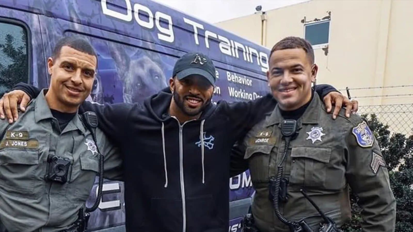 Jas Leverette with two San Jose Police K-9 officers and their dogs in front of the Cali K9 training van